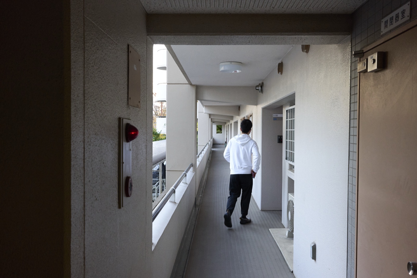 廊下をひとりで歩いていく介護士の後ろ姿